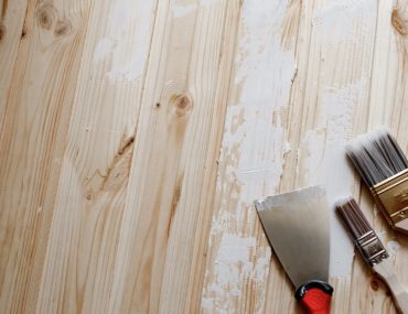 Spatula, putty paste, brush on a peeling wooden wall